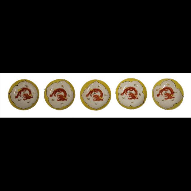 A color photograph of five Chinese sauce dishes. All five are yellow plates with matching patterns. There is an outline of a white flower and a red dragon in the center. The dragons have yellow highlights. 